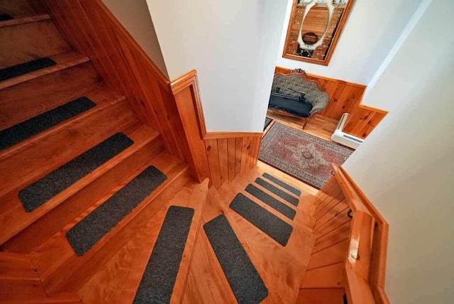 staircase featuring hardwood / wood-style flooring and wood walls