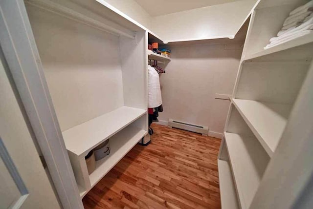 walk in closet featuring wood-type flooring and a baseboard radiator