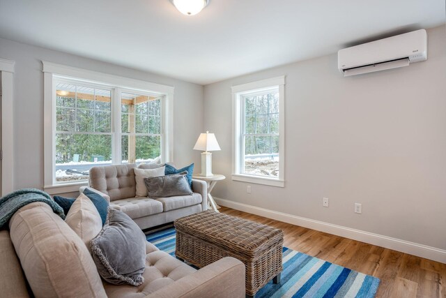 living room with light hardwood / wood-style floors, a wealth of natural light, and a wall mounted air conditioner