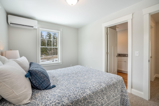 bedroom featuring baseboards, light colored carpet, and a wall mounted air conditioner