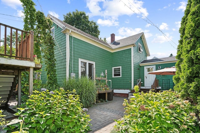 back of property featuring a wooden deck and a patio area