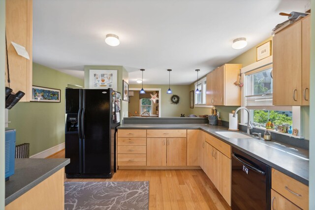 kitchen featuring black appliances, kitchen peninsula, sink, light brown cabinets, and light wood-type flooring