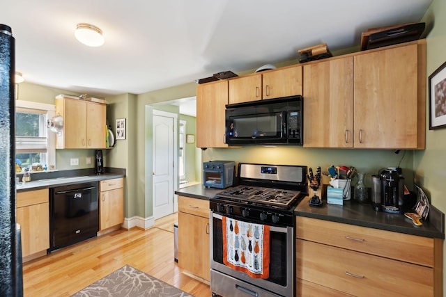 kitchen with black appliances, light brown cabinetry, and light hardwood / wood-style floors