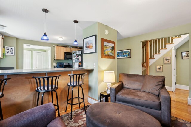 living room with bar area and light hardwood / wood-style floors