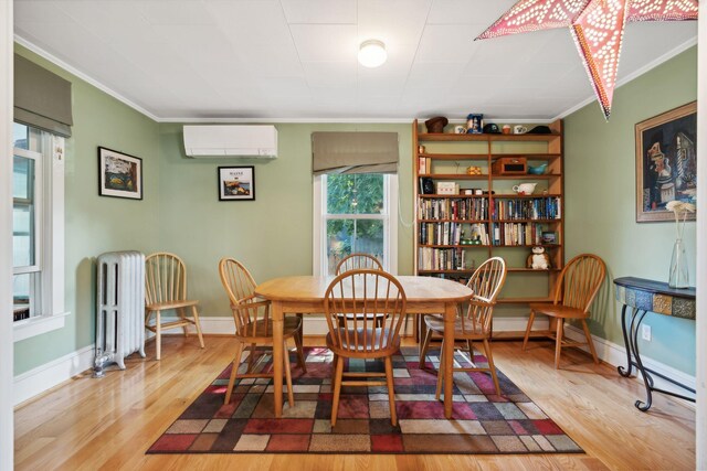 dining space featuring ornamental molding, a wall mounted AC, radiator, and hardwood / wood-style flooring