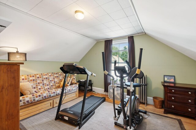 workout room with hardwood / wood-style flooring and vaulted ceiling