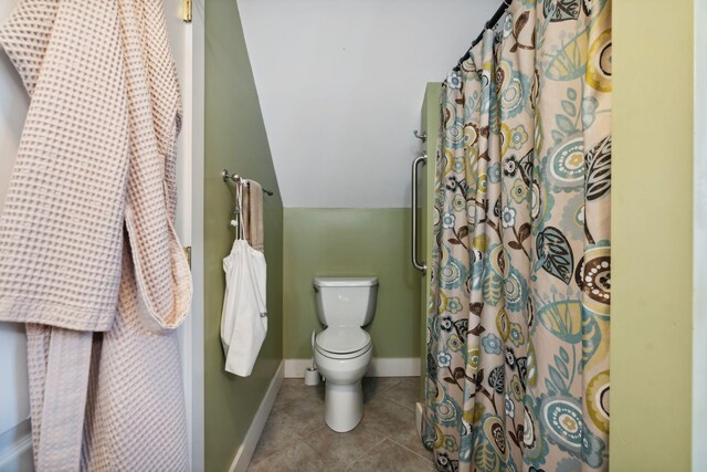 bathroom featuring vaulted ceiling, toilet, and tile patterned flooring