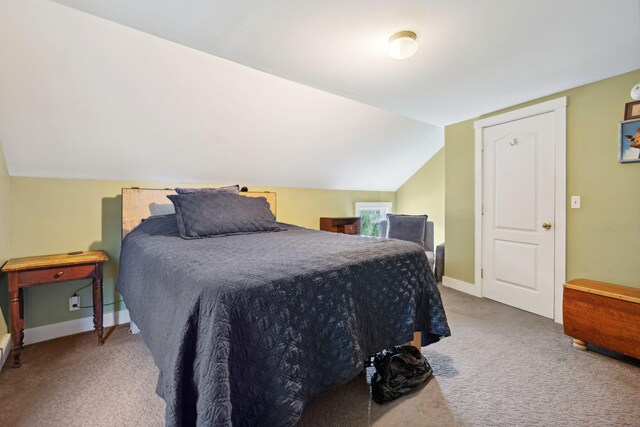 carpeted bedroom with lofted ceiling