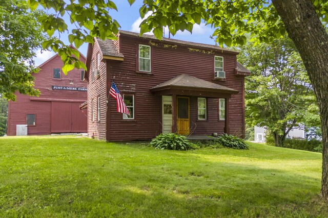 view of front of house with cooling unit and a front lawn