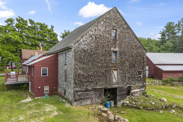 view of side of property with a lawn and a deck