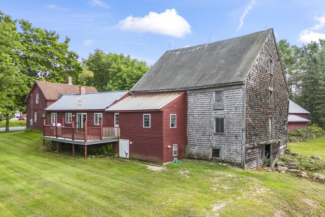 rear view of property featuring a wooden deck and a yard