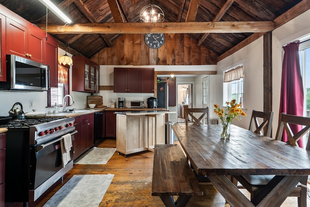 kitchen featuring wooden ceiling, vaulted ceiling with beams, stainless steel appliances, and light wood-type flooring