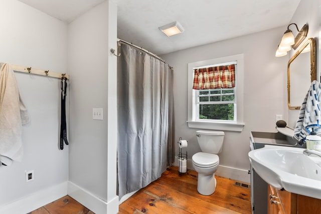 bathroom featuring toilet, hardwood / wood-style floors, and vanity