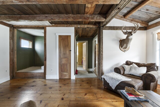 unfurnished living room with hardwood / wood-style flooring, vaulted ceiling with beams, and wood ceiling