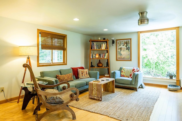 living area with baseboards, wood finished floors, and recessed lighting