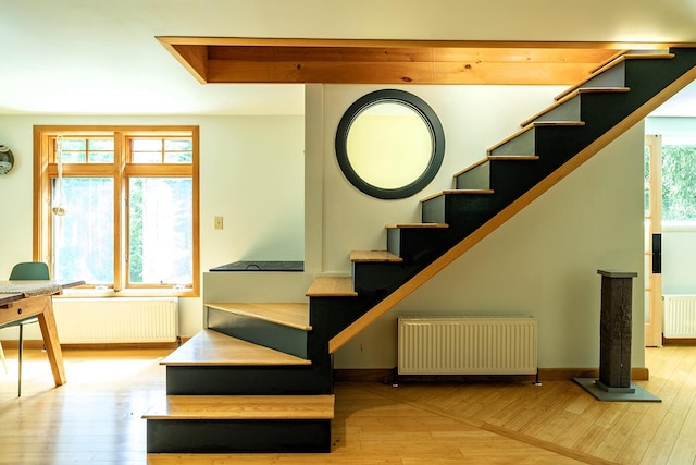 stairway featuring radiator, baseboards, and wood finished floors