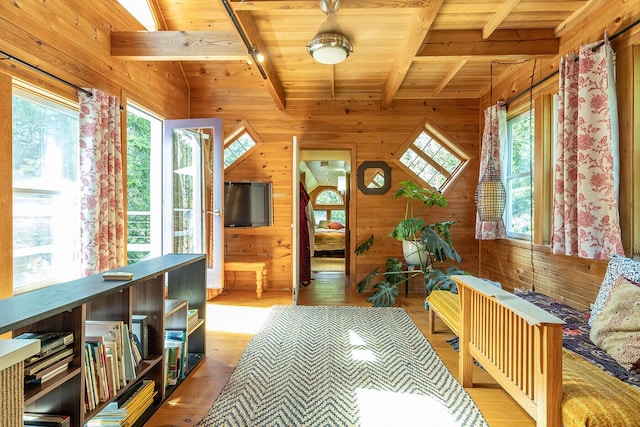 hallway featuring wood walls, wooden ceiling, beam ceiling, and light wood-style floors