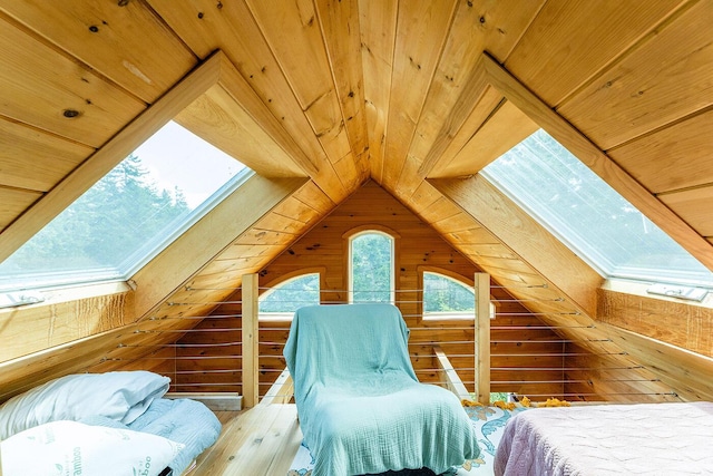 bedroom featuring lofted ceiling with skylight, wood ceiling, and wooden walls