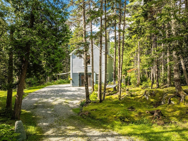 view of side of property featuring gravel driveway