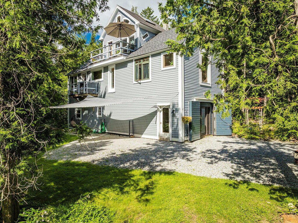 11 Jack Rabbit Rd, Northport, ME 04849 - back of property featuring a balcony, driveway, and a yard