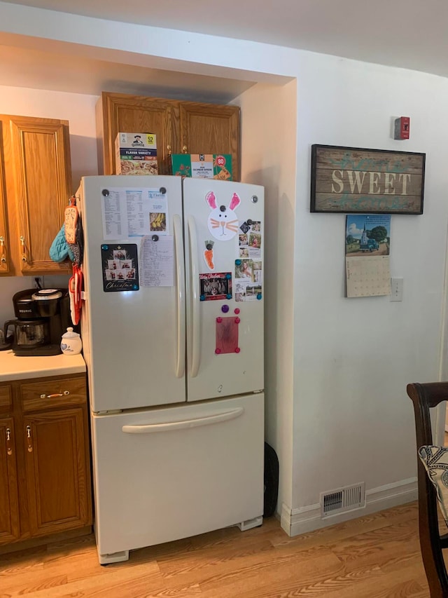 kitchen featuring light wood-type flooring and white fridge