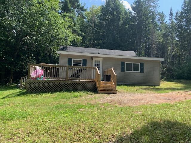 view of front facade with a deck and a front yard