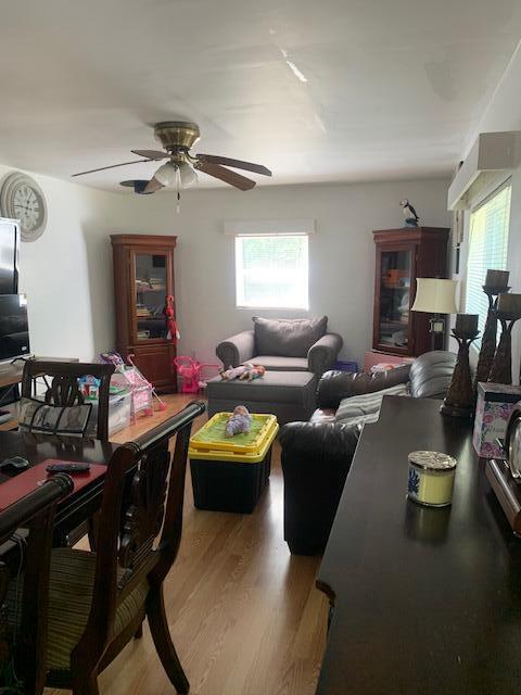 living room featuring hardwood / wood-style floors and ceiling fan