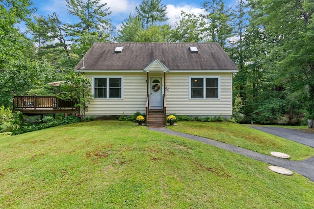 view of front of home with a front yard and a deck