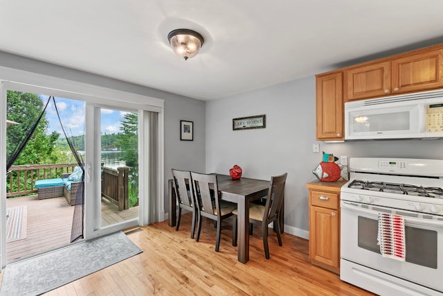 kitchen with light wood-type flooring and white appliances