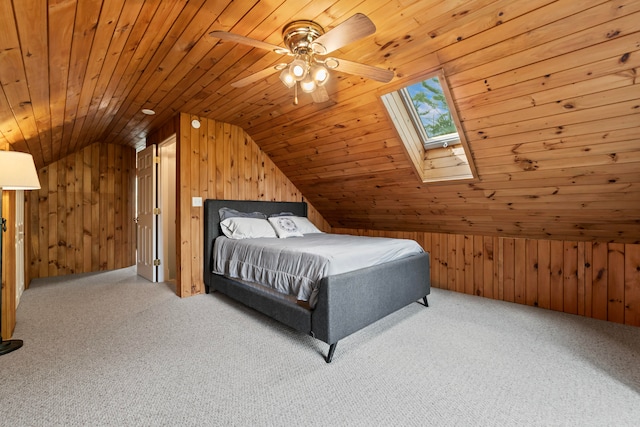 carpeted bedroom with wooden ceiling, ceiling fan, wood walls, and lofted ceiling with skylight