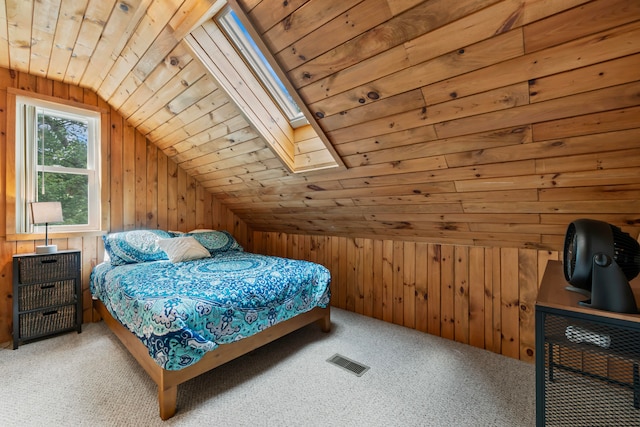 carpeted bedroom with wooden walls, wooden ceiling, and lofted ceiling with skylight