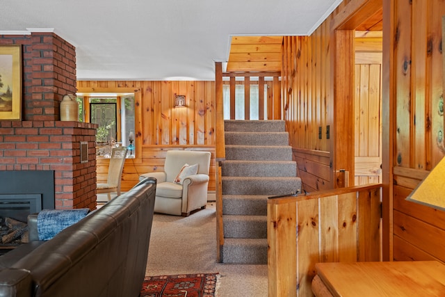 carpeted living room with plenty of natural light, wood walls, and a brick fireplace