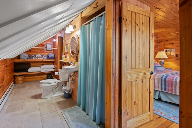 bathroom featuring wood walls, baseboard heating, lofted ceiling, and toilet