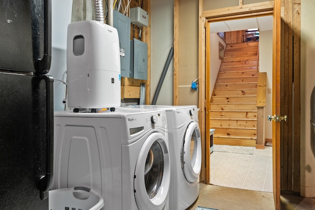 laundry room featuring wood walls, electric panel, and light tile patterned floors