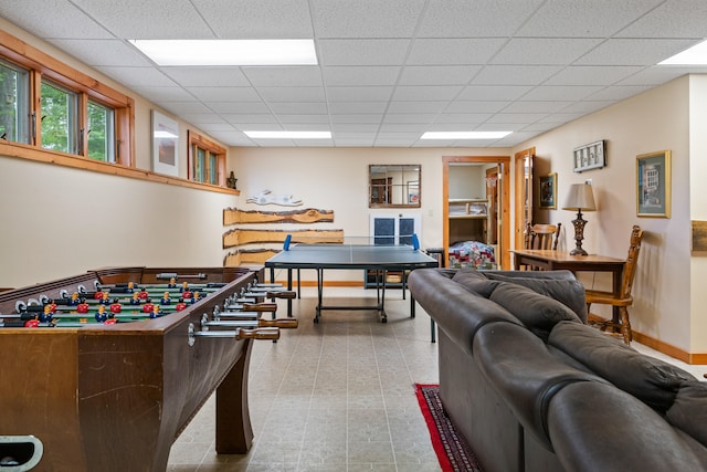 recreation room featuring a paneled ceiling and light tile patterned flooring