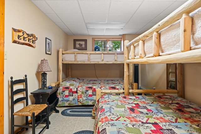 tiled bedroom featuring a drop ceiling