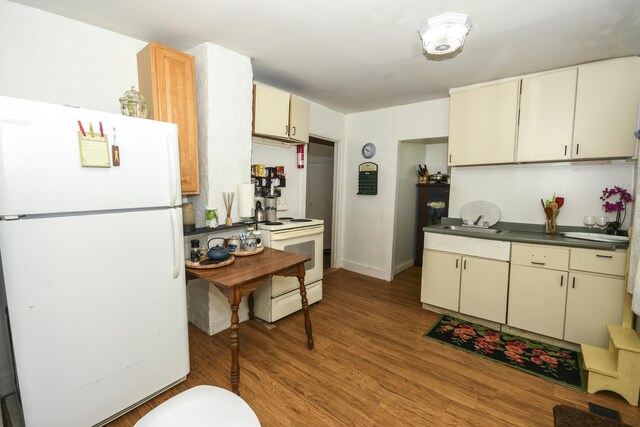 kitchen featuring light hardwood / wood-style floors, cream cabinetry, and white appliances