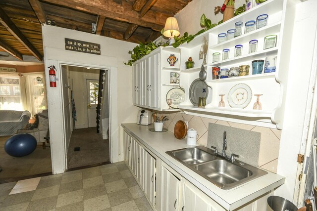 kitchen featuring plenty of natural light, sink, tasteful backsplash, and white cabinetry