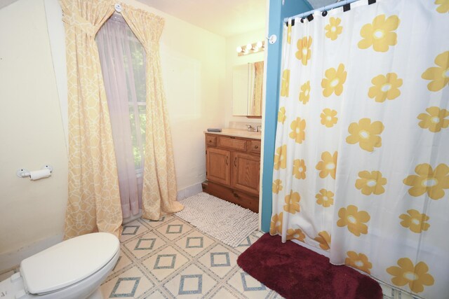 bathroom with walk in shower, vanity, and toilet