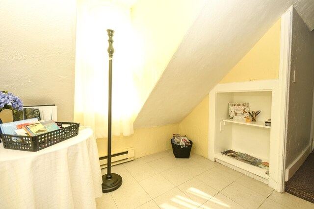 bonus room featuring tile patterned floors and a baseboard radiator