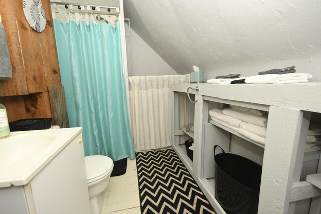 bathroom featuring vaulted ceiling, a shower with curtain, vanity, and toilet