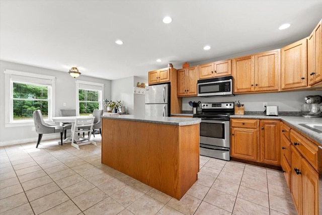 kitchen with light tile patterned flooring, stainless steel appliances, and a center island