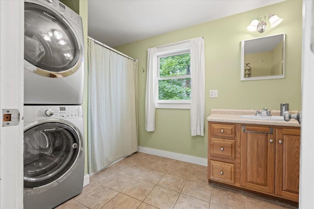 washroom featuring sink, stacked washer / dryer, light tile patterned floors, and a chandelier