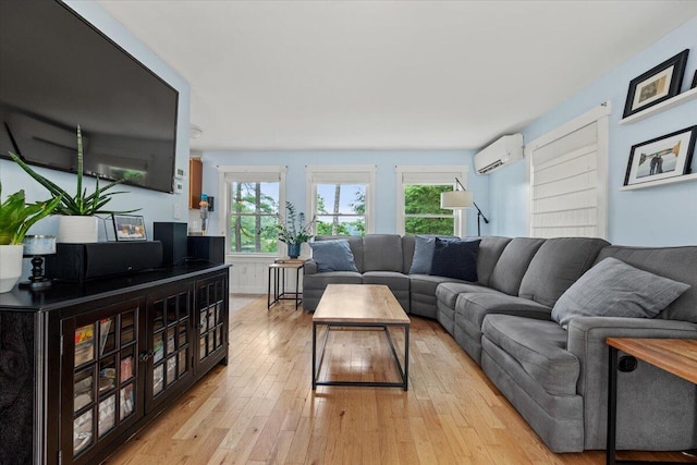 living room with light hardwood / wood-style floors and a wall mounted air conditioner