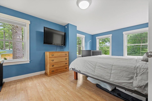 bedroom with light wood-type flooring and multiple windows