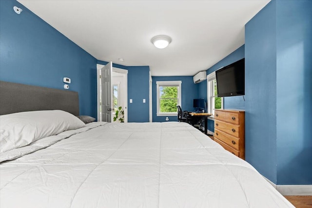 bedroom featuring hardwood / wood-style flooring and a wall mounted AC