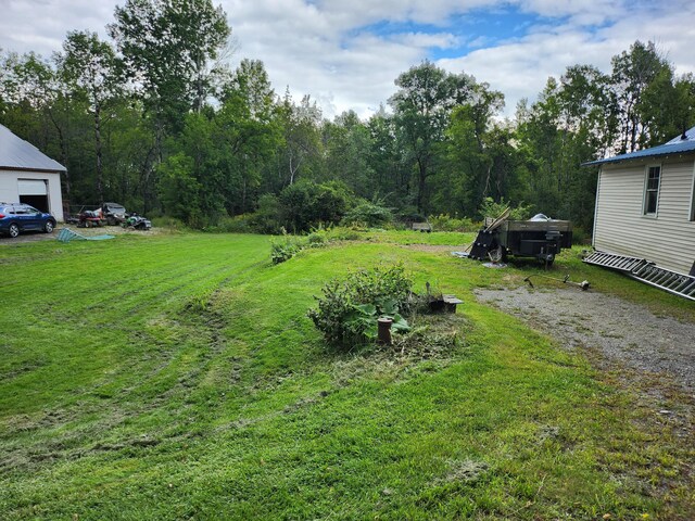 view of yard featuring a garage and an outdoor structure