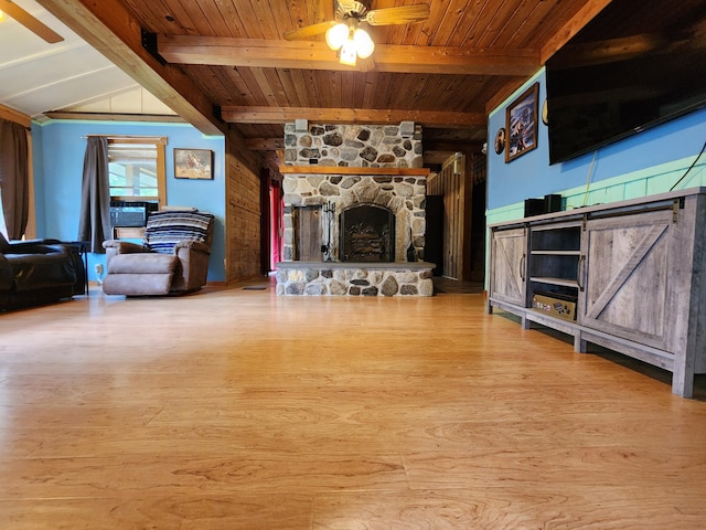 living room with light hardwood / wood-style flooring, a stone fireplace, ceiling fan, wood ceiling, and lofted ceiling with beams