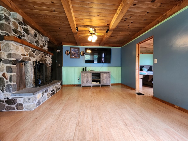 unfurnished living room with a fireplace, beamed ceiling, wood ceiling, and wood-type flooring