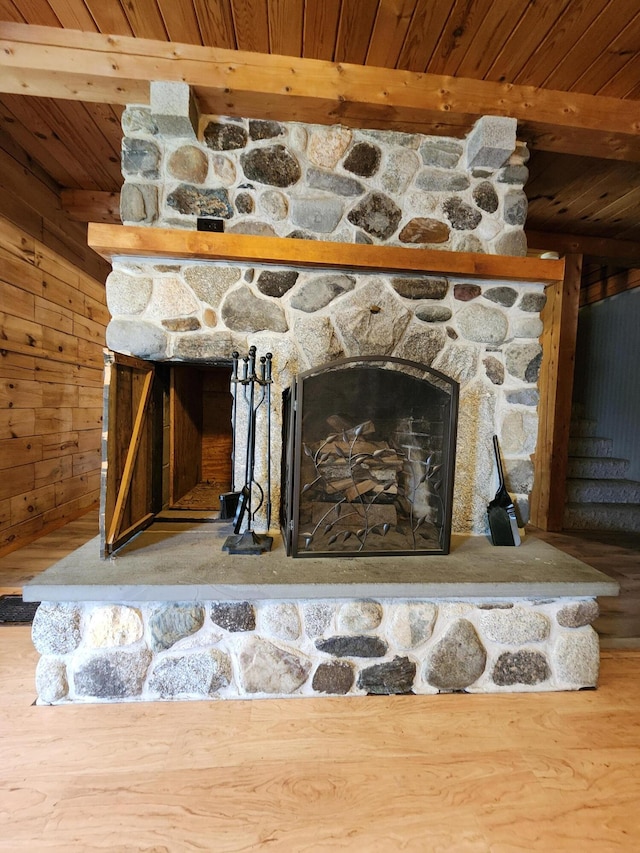 interior details with a fireplace, hardwood / wood-style flooring, wooden ceiling, beamed ceiling, and wooden walls